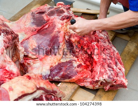 a butcher cuts a fresh beef carcass