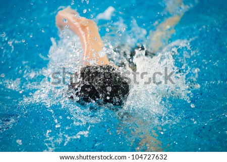 a swimmer swims in an indoor pool