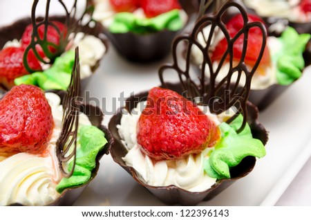 buffet dessert - strawberries with whipped cream in chocolate baskets