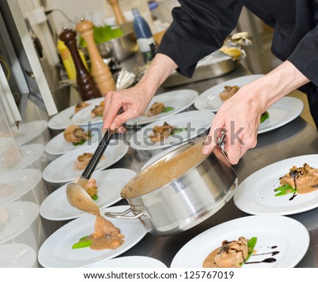 chef pours sauce over meat pieces on plates