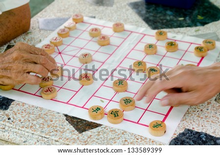hands of senior men playing Chinese chess