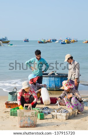 MUI NE, VIETNAM - MARCH 6: Unidentified women sort out the fish their husbands have caught, March 6, 2013, Mui Ne, Vietnam. Fishing is the main source of income for local villagers.