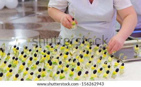off-premise catering - waitresses put fruit canapes on buffet table