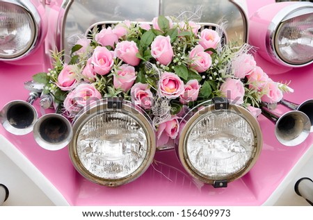 a bunch of pink roses at a retro car front