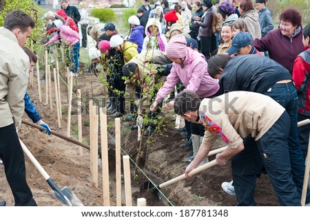 ULAN-UDE, RUSSIA - MAY 20, 2011: Unidentified adults and children plant young trees near the City Palace of Childrens Arts. Children who now attend the palace and its graduates work together.
