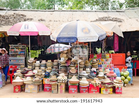 ANGKOR, CAMBODIA - FEB 21, 2013: Unidentified tradeswomen sell various hats at a little market. The Angkor Khmer complex is the prime tourists attraction in the country.