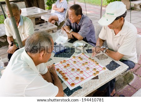 BANGKOK, THAILAND - FEB 17, 2013: Unidentified local senior men spend spare time playing Chinese chess in the street.