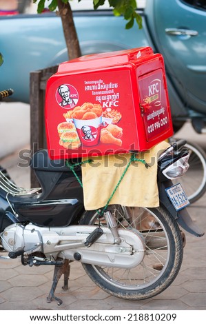 SIEM REAP, CAMBODIA - JUNE 29, 2014: A box for delivery of KFC food placed on a motorcycle. Kentucky Fried Chicken is a fast food restaurant chain, the second largest one in the world.