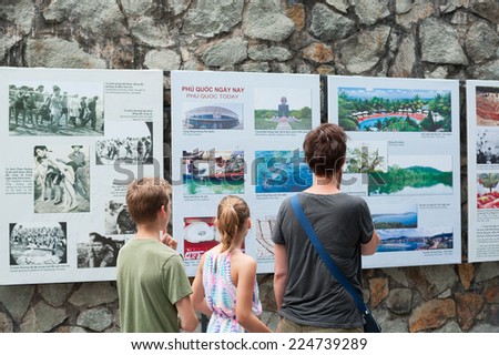 HO CHI MINH, VIETNAM - JULY 15, 2014: A Caucasian woman and two kids watch photographs at the War Remnants Museum, at the building reproducing \
