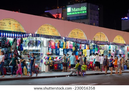 HO CHI MINH, VIETNAM - JULY 10, 2014: Unidentified people sell and buy clothes and souvenirs at the Ben Thanh market. At the market tourists can find local souvenirs and handicrafts.