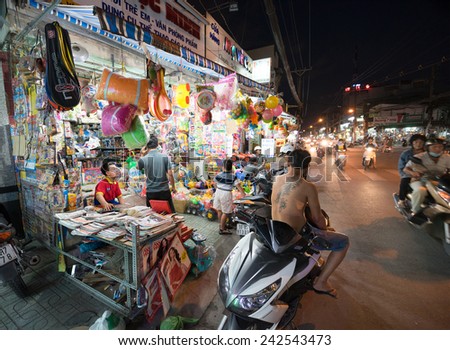 HO CHI MINH, VIETNAM - DECEMBER 28, 2014: Unidentified people sell and buy things in the evening in Le Van Tho street. Many shops and stores open at sunset - about 5 or 6 p.m.