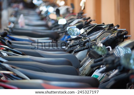 many motorcycles in a line at a downtown parking lot