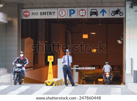 HO CHI MINH, VIETNAM - JAN 15, 2015: An unidentified security guard stands at the entrance to an underground parking. Usual city parking lots are intended for motorcycles not cars.