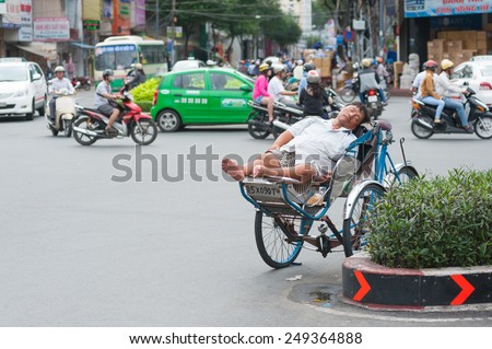 HOCHIMINH, VIETNAM - JULY 6, 2014: An unidentified Vietnamese cyclo driver sleeps in his vehicle on the road.