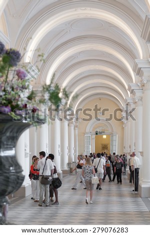 ST. PETERSBURG - JUNE 30, 2011: Unidentified people walk and watch at one of the Hermitage halls. Over 3 million people visit the museum every year.