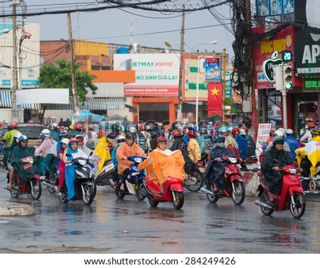 HOCHIMINH, VIETNAM - MAY 28, 2015: A lot of motorcyclists in raincoats drive in the rain in Phan Van Tri Street during rush hours. The main means of transport in Vietnam is motorcycle.