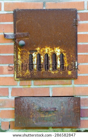 rusty door of Finnish sauna stove, with ashbox below
