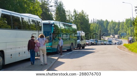 NUIJAMAA, FINLAND - JUNE 1, 2011: Unidentified vehicles wait in a long queue for their passports control at the Finnish border checkpoint. It works 24 hours and open for citizens of all countries.