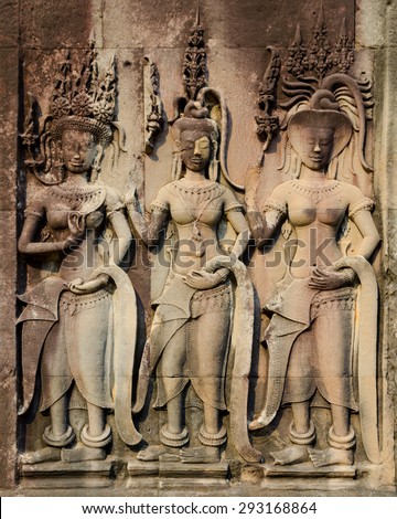 low relief in Angkor - three female statues in crowns - Apsarases, female spirits of clouds and waters in Hindu and Buddhist mythology