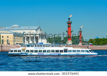 ST. PETERSBURG - MAY 31, 2011: A motor ship of the Vodohod tour company carries tourists by the Spit of Vasilyevsky Island. There are Rostrum columns and the Old St. Petersburg Stock Exchange there.
