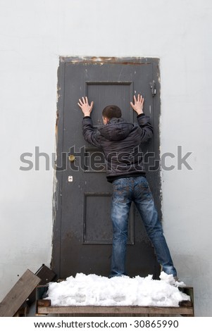 man knocking at closed metal grunge door