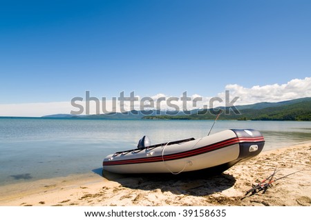inflatable boat wth fishing rod at lake shore