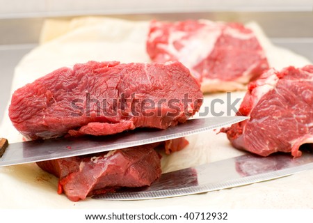 pieces of fresh beef with butchers knives