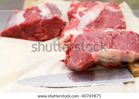 pieces of fresh beef with butchers knives