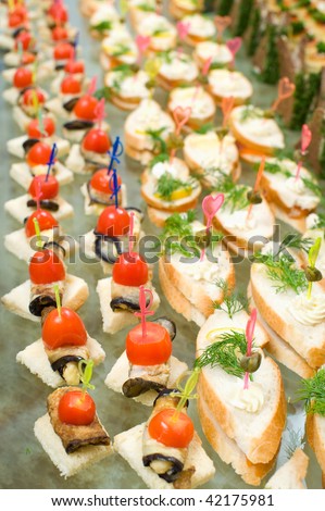 a lot of canapes with skewers and sandwiches on buffet table, shallow DOF