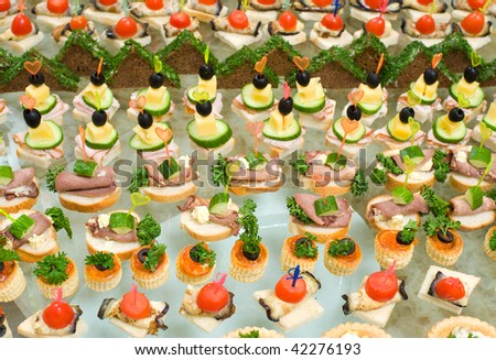 a lot of canapes with skewers and sandwiches on buffet table, shallow DOF