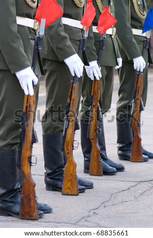 guard of honour - line of soldiers in full dress with their guns beside - lower half