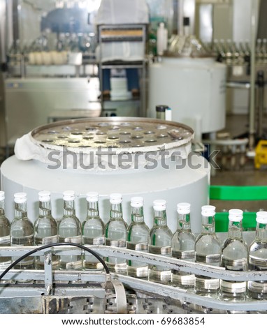 many bottles of vodka at production line of distillery