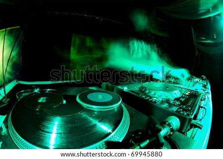 blurred dj at spin table in night club