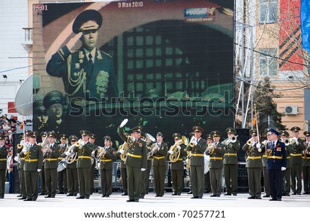 ULAN-UDE, RUSSIA - MAY 9: A marching band is in front of a TV panel broadcasting from Moscow, at the parade on annual Victory Day, May, 9, 2010 in Ulan-Ude, Buryatia, Russia.