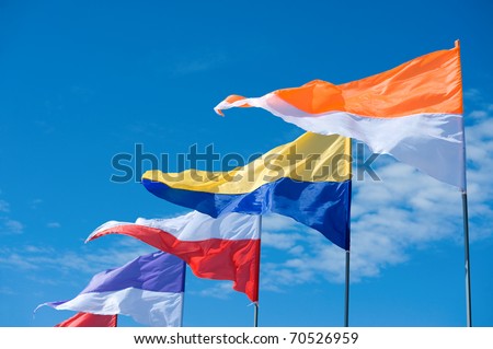 a line of triangle two-colour flags flying against blue sky