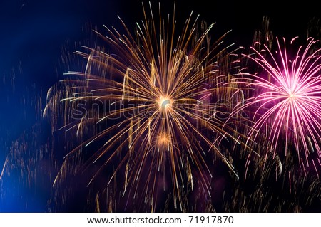 pink and orange flashes of a festive firework in the night sky
