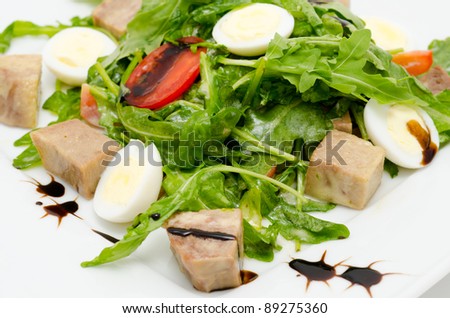 salad - egg halves, pork cubes, roquette and tomatoes