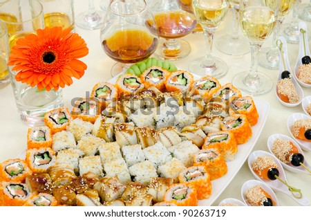 a lot of sushi and drinks on buffet table, catering
