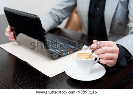 a business woman stirs coffee in a cup