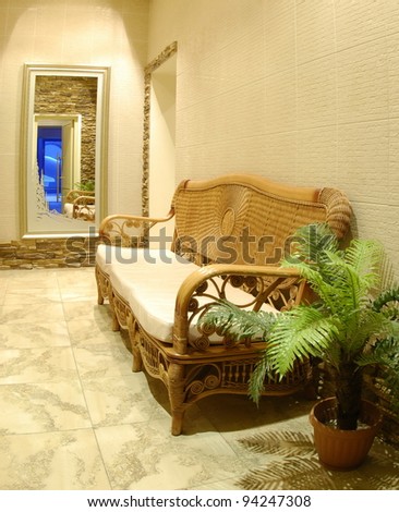 hall interior - walls revetted with artificial stones, a wicker sofa