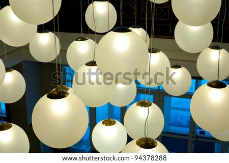 many round ceiling lamps hang at different height