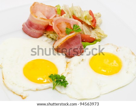 fried bacon and eggs with vegetable salad