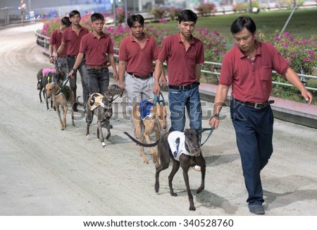 VUNGTAU, VIETNAM - JUNE 12, 2015: Unidentified trainers present their dogs before the dogs race. It is the only gambling allowed in communist Vietnam.