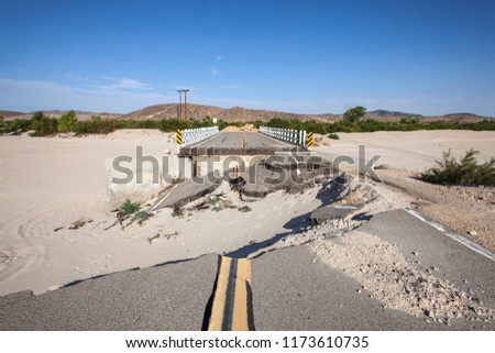 Washed out flood damaged highway road and bridge in the Mojave desert near Barstow, California.
