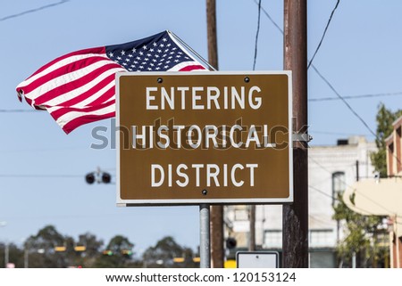 Entering historical district road sign with American Flag.