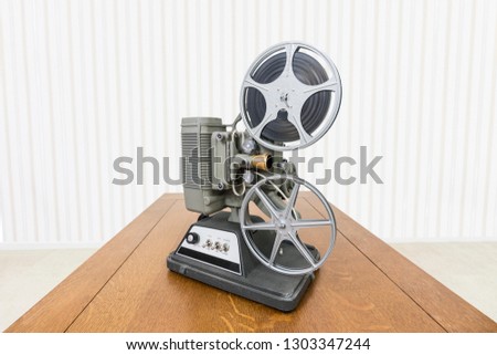 Vintage 8mm home movie projector on wood table.