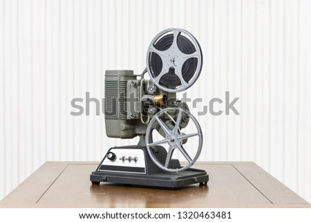 Antique 8mm home movie projector on wood table.
