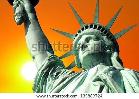 New York\'s Statue of Liberty with setting sun.