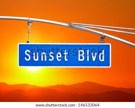 Sunset Blvd overhead street sign with orange dusk sky.