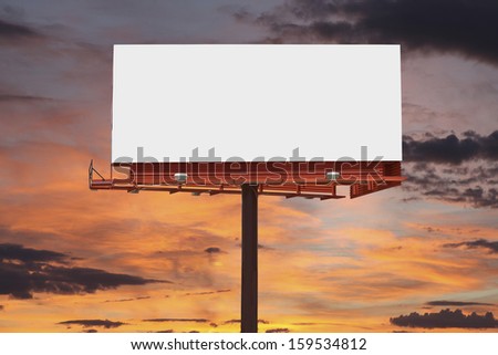 Big blank billboard with orange sunset sky.